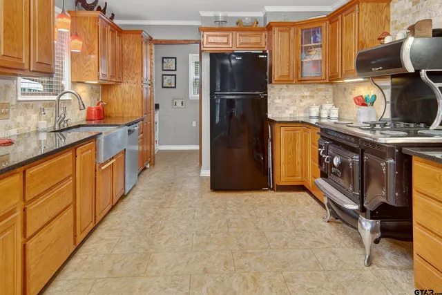 a kitchen with stainless steel appliances granite countertop a refrigerator a stove and a sink