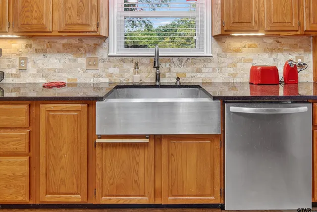 a kitchen with stainless steel appliances granite countertop a sink stove and cabinets