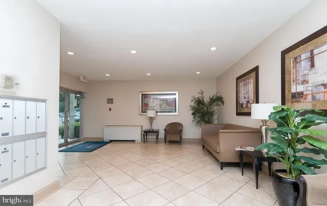 a living room with furniture a window and a potted plant