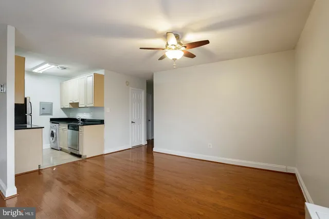 a view of kitchen with a sink wooden floor and a refrigerator