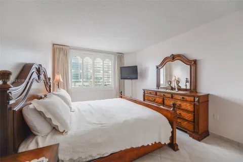 a bedroom with a bed a dresser and mirror