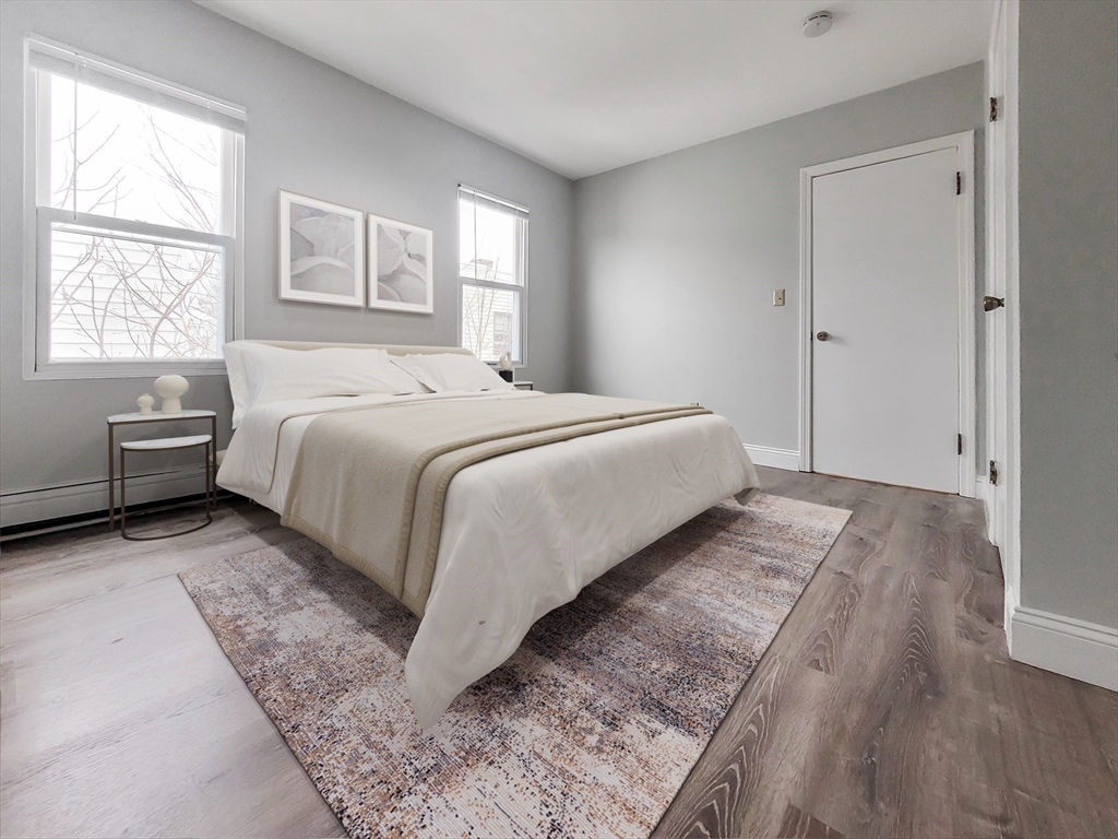 49 Rosedale Street, Unit 3 Boston, MA 02124 - Photo 4 of 10 a bedroom with a bed and wooden floor