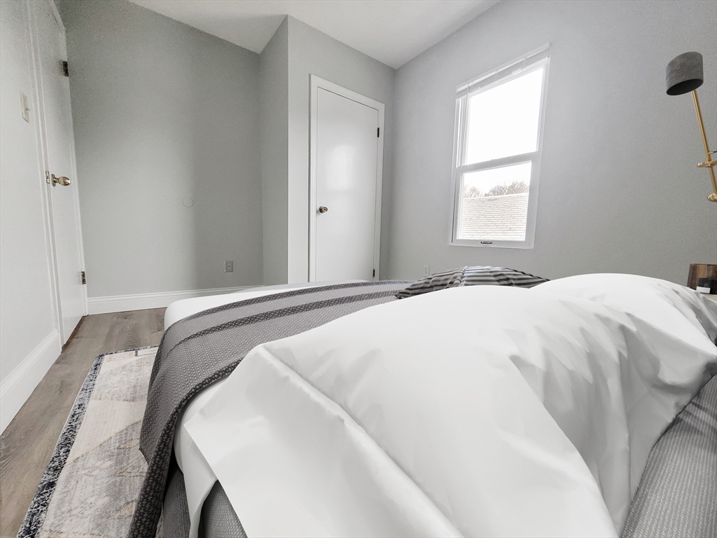 49 Rosedale Street, Unit 3 Boston, MA 02124 - Photo 8 of 10 a bedroom with a bed and a window