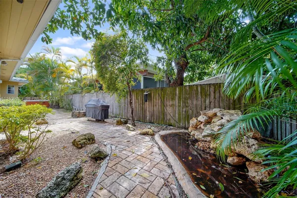 a backyard of a house with barbeque oven and outdoor seating
