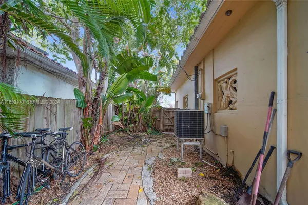 a view of backyard with wheel chair potted plants and large tree