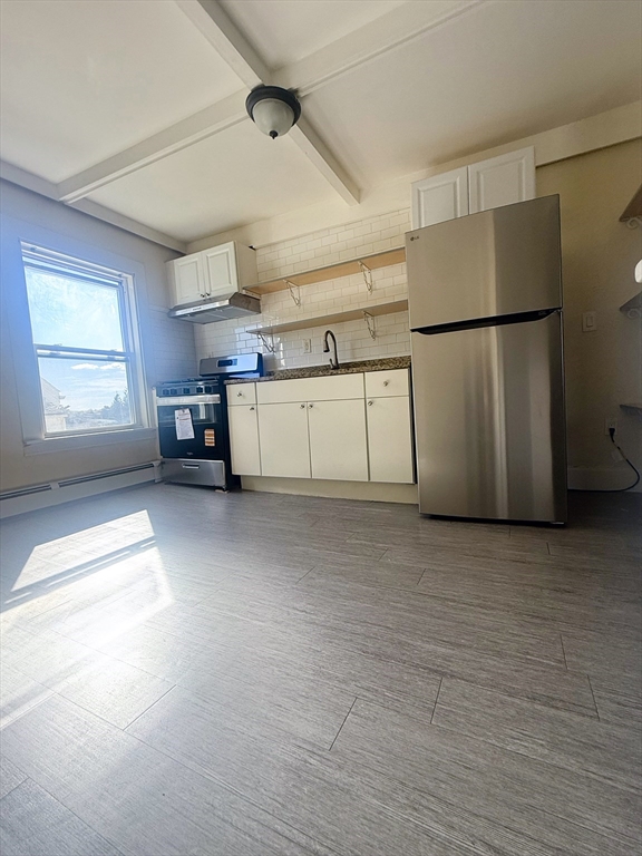 a view of a kitchen with refrigerator and window