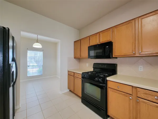 a kitchen with granite countertop a refrigerator stove and microwave