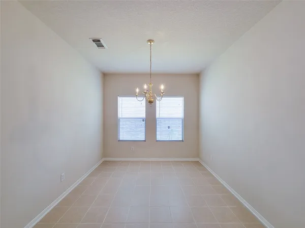 an empty room with windows and chandelier