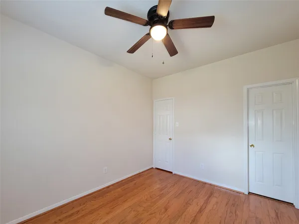an empty room with a window and a ceiling fan