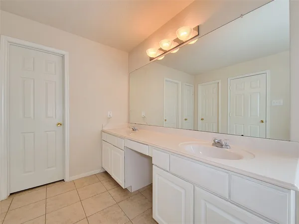 a spacious bathroom with a sink and a mirror
