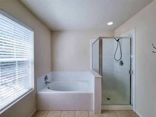 a bathroom with a bath tub a shower and vanity