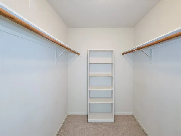 a view of walk in closet with empty racks