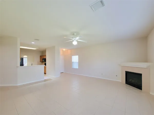 an empty room with windows and fireplace