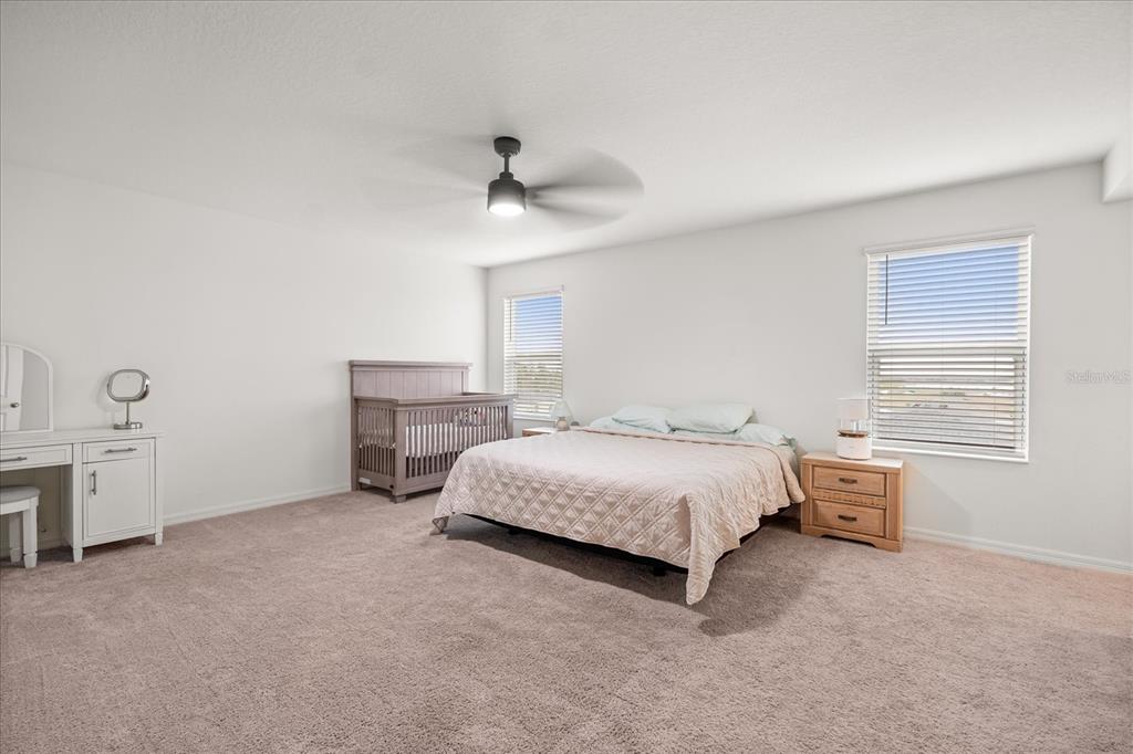 1470 Geranium Drive Mascotte, FL 34753 - Photo 14 of 23 a spacious bedroom with a bed and a chandelier