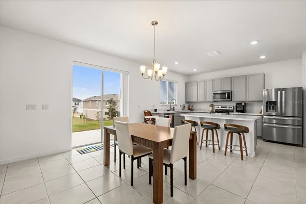 a kitchen with appliances cabinets and chair