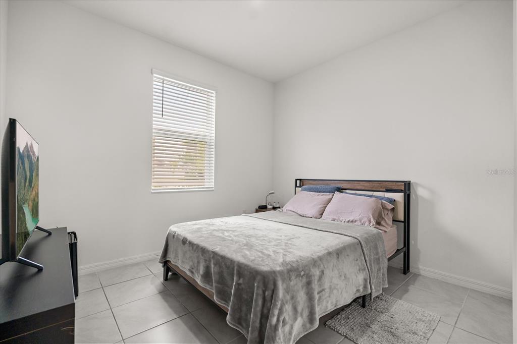 1470 Geranium Drive Mascotte, FL 34753 - Photo 10 of 23 a bedroom with a bed a television and dresser