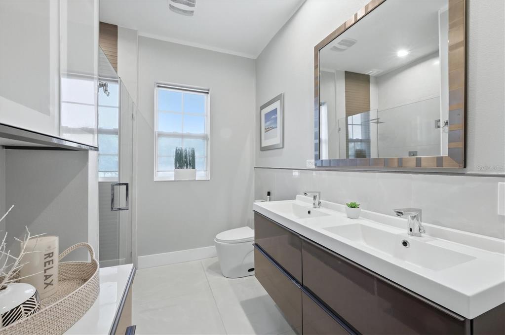 1112 Seneca Road Venice, FL 34293 - Photo 31 of 50 a bathroom with a double vanity sink mirror and toilet