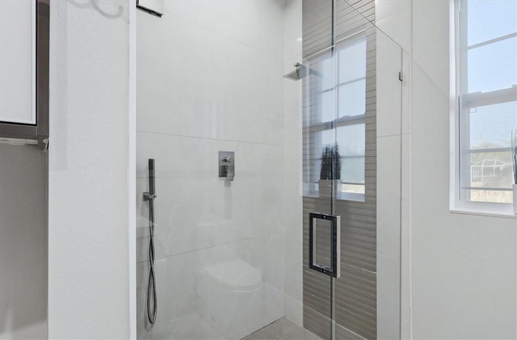 1112 Seneca Road Venice, FL 34293 - Photo 32 of 50 a bathroom with a glass shower door