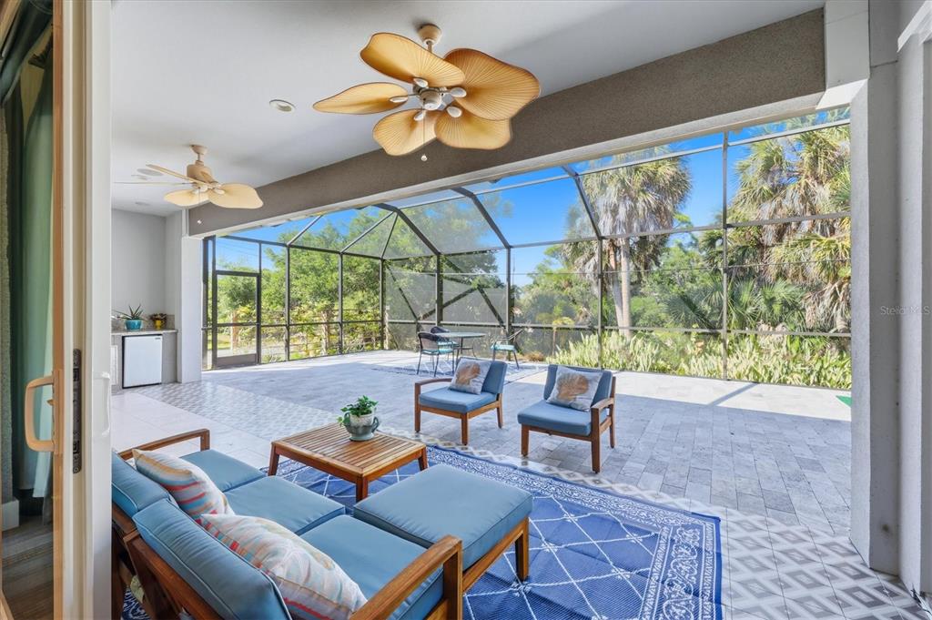 1112 Seneca Road Venice, FL 34293 - Photo 35 of 50 a living room with patio furniture and a floor to ceiling window