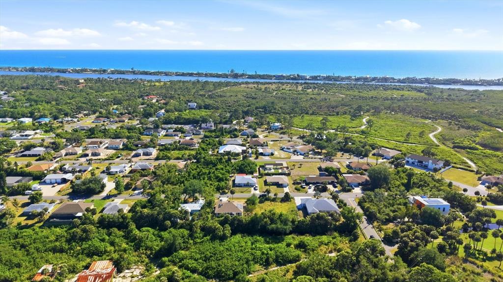 1112 Seneca Road Venice, FL 34293 - Photo 44 of 50 an aerial view of a city with lots of residential buildings and mountain view in back