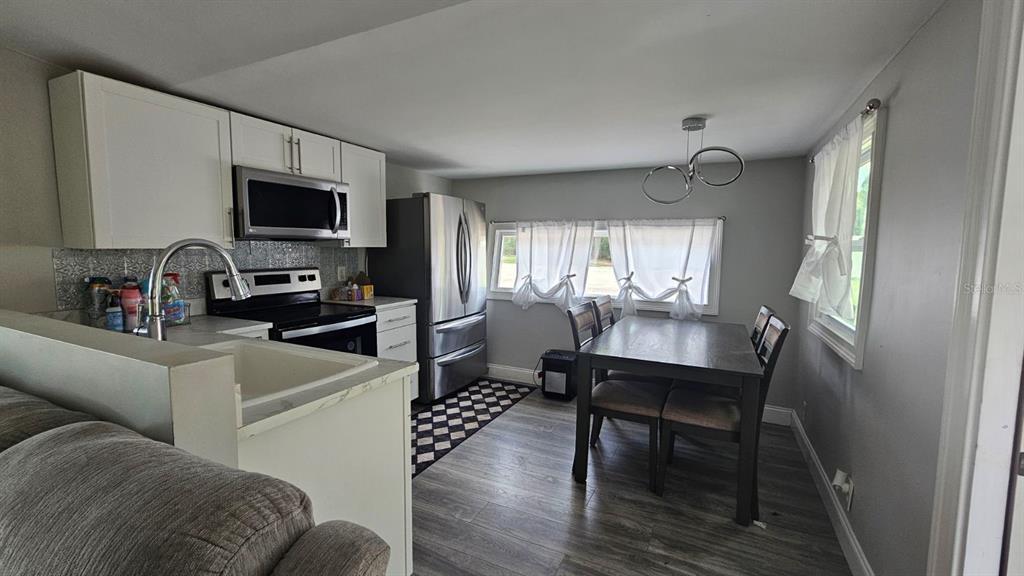 7127 West Grover Cleveland Boulevard, Unit 48 Homosassa, FL 34446 - Photo 3 of 18 a view of a livingroom with furniture a flat screen tv and wooden floor