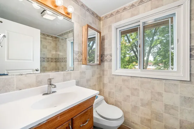 a bathroom with a sink a toilet and a window