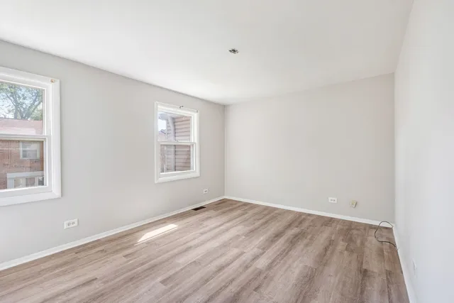 a view of a room that has wooden floor and windows in it