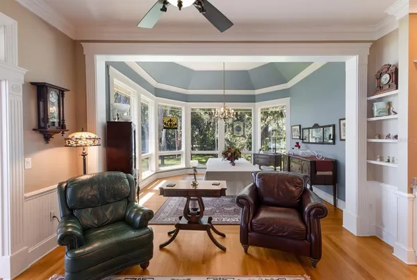 a dining room with furniture a large window and a rug