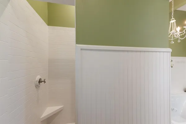 a bedroom with a bed windows and a chandelier