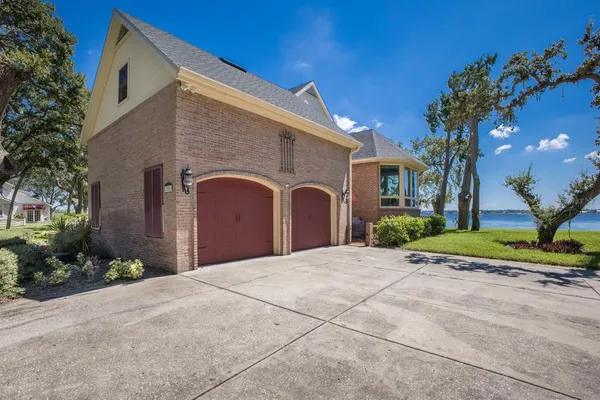 a front view of a house with garden and trees