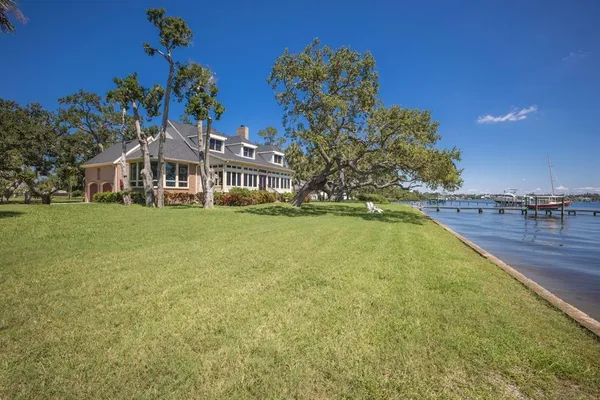 a view of a house with a yard and large tree