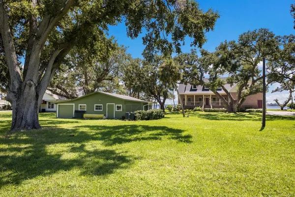 an aerial view of residential house with outdoor space and trees all around