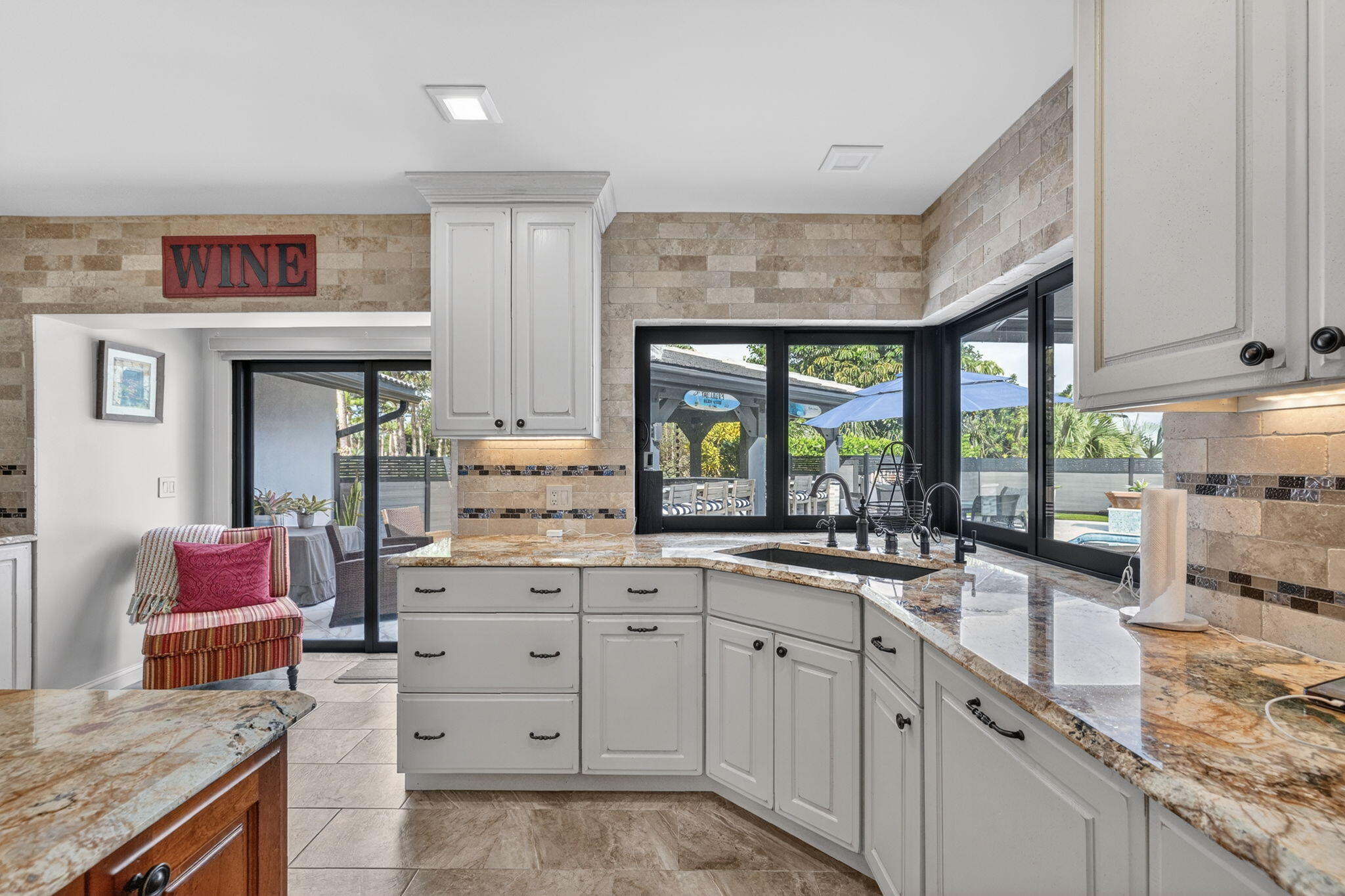5212 Foxpointe Circle Delray Beach, FL 33445 - Photo 17 of 89 a kitchen with granite countertop a sink window and cabinets