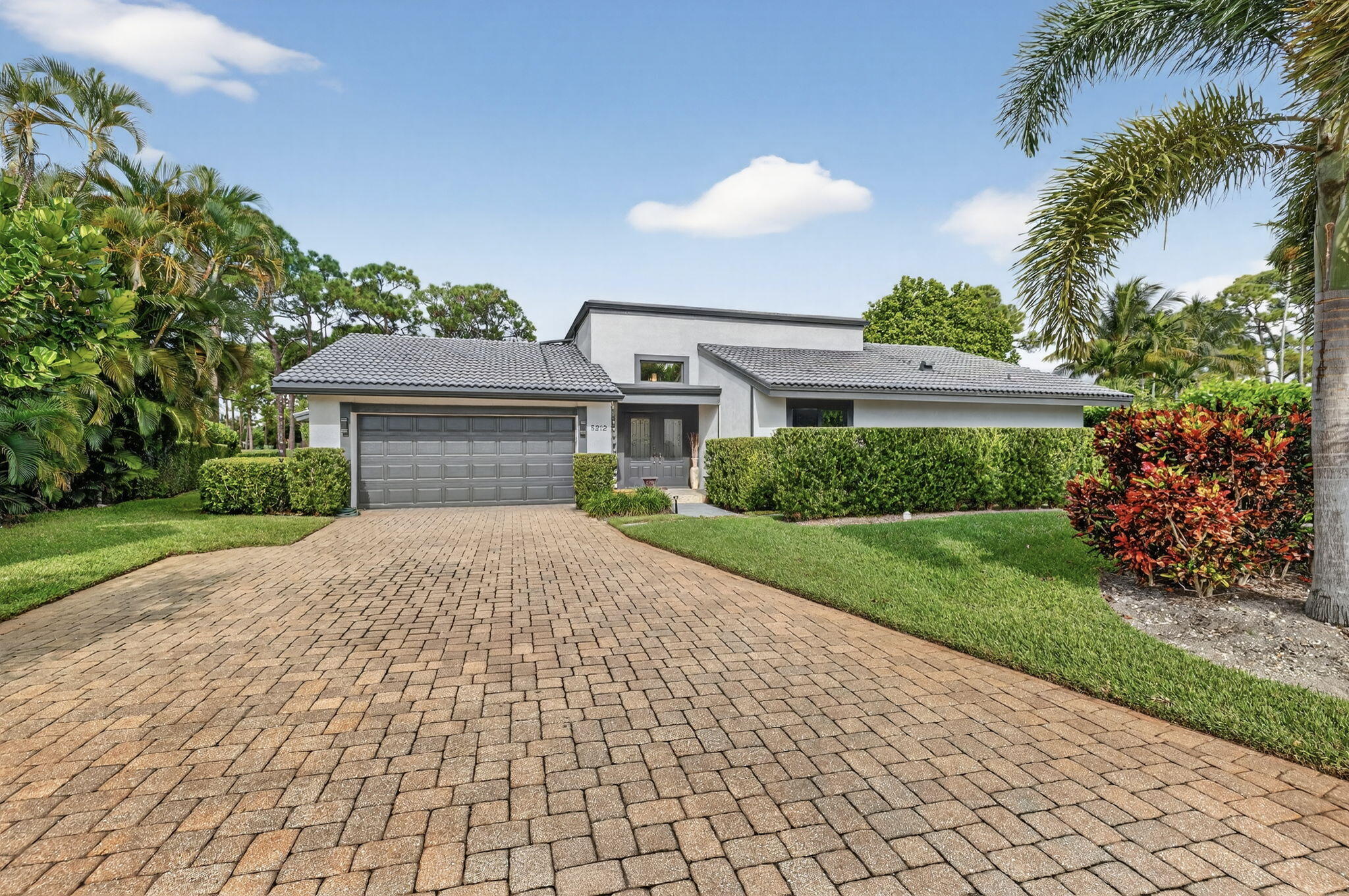 5212 Foxpointe Circle Delray Beach, FL 33445 - Photo 3 of 89 a front view of a house with a yard and a garage