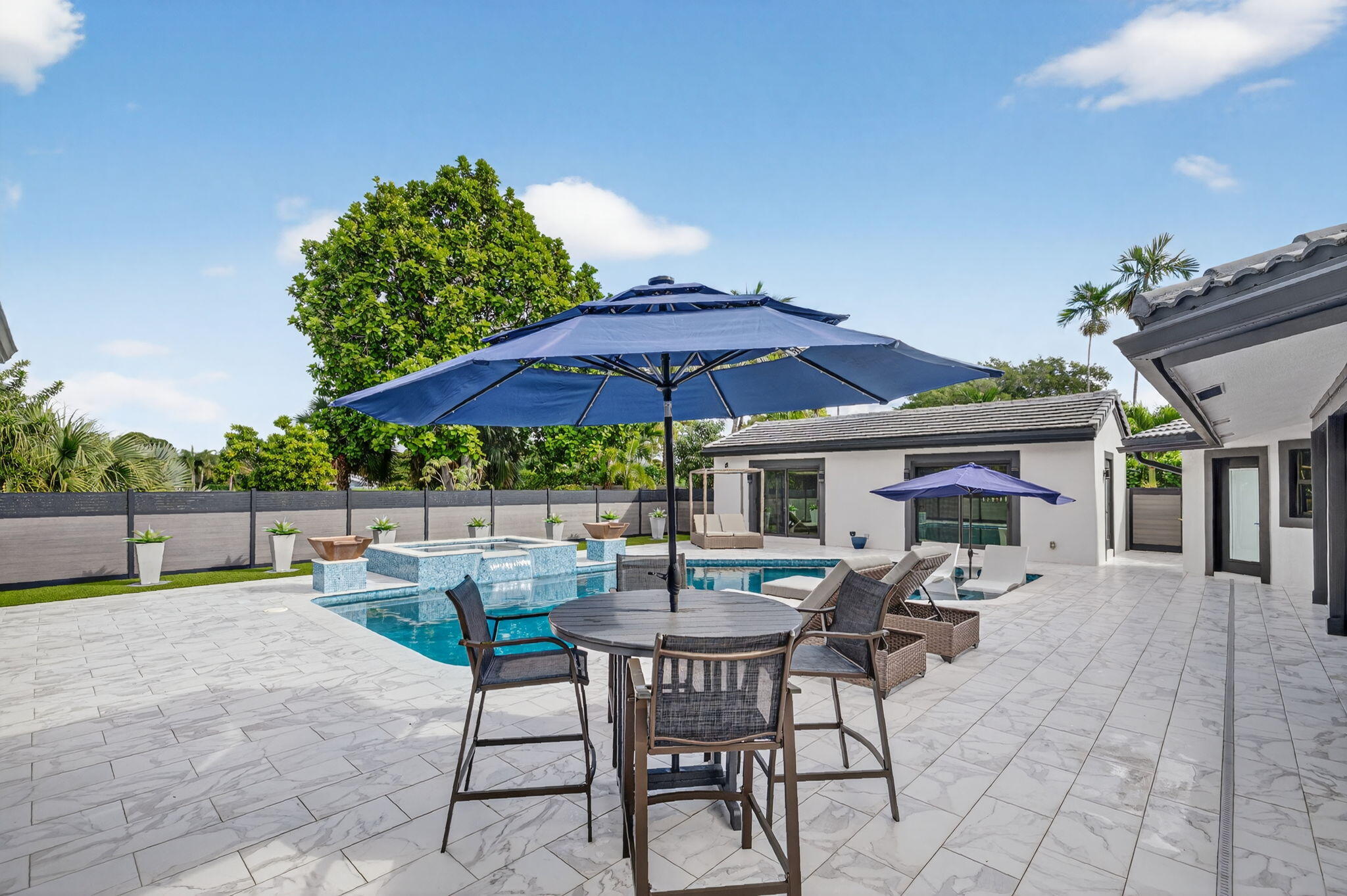 5212 Foxpointe Circle Delray Beach, FL 33445 - Photo 55 of 89 a patio with a table and chairs under an umbrella