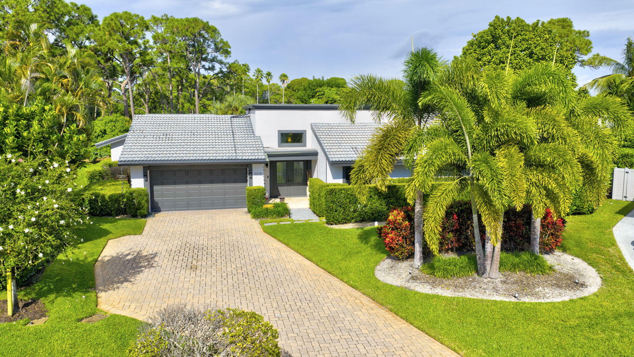 5212 Foxpointe Circle Delray Beach, FL 33445 - Photo 62 of 89 a front view of a house with a yard and trees