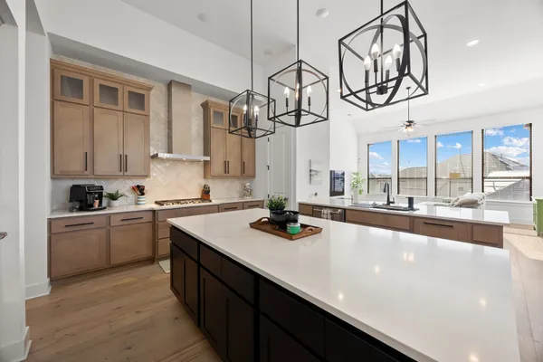 a kitchen with a sink appliances and a chandelier