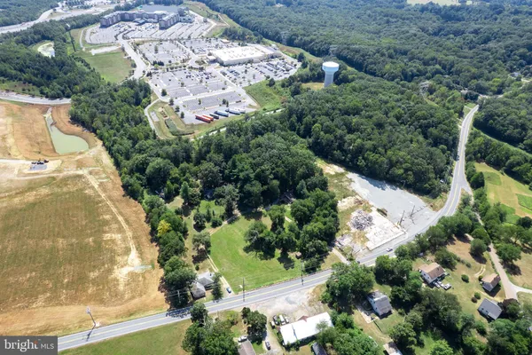 an aerial view of residential house with outdoor space and trees all around