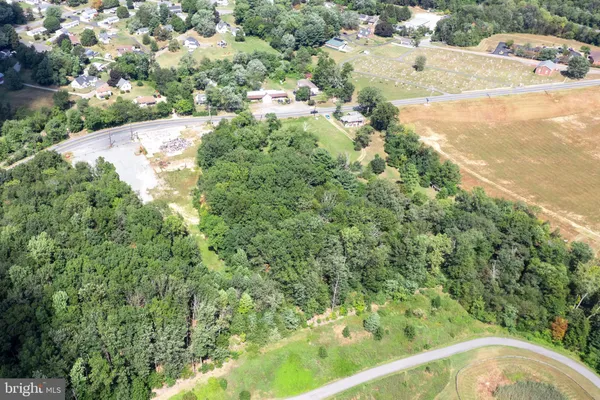 an aerial view of residential houses with outdoor space and trees