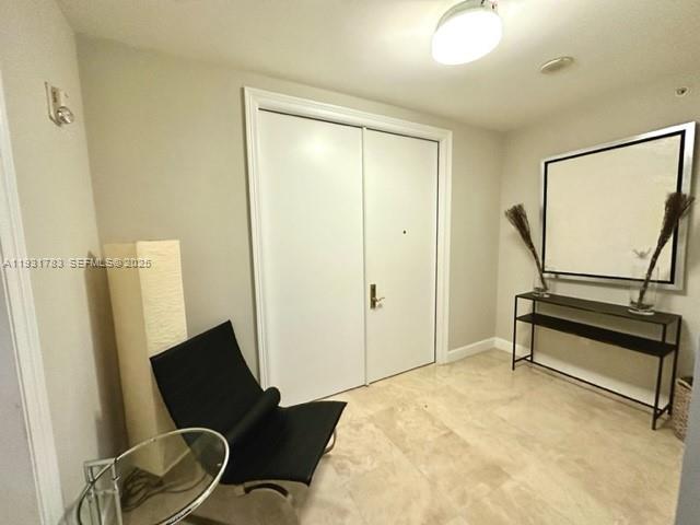 20201 East Country Club Drive, Unit 903 Aventura, FL 33180 - Photo 10 of 61 a bedroom with a chair and wooden floor
