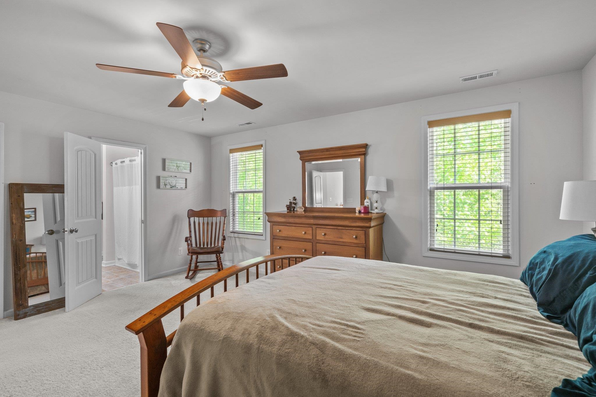 104 Griffis Drive Stem, NC 27581 - Photo 17 of 37 a bedroom with a large bed and a chandelier