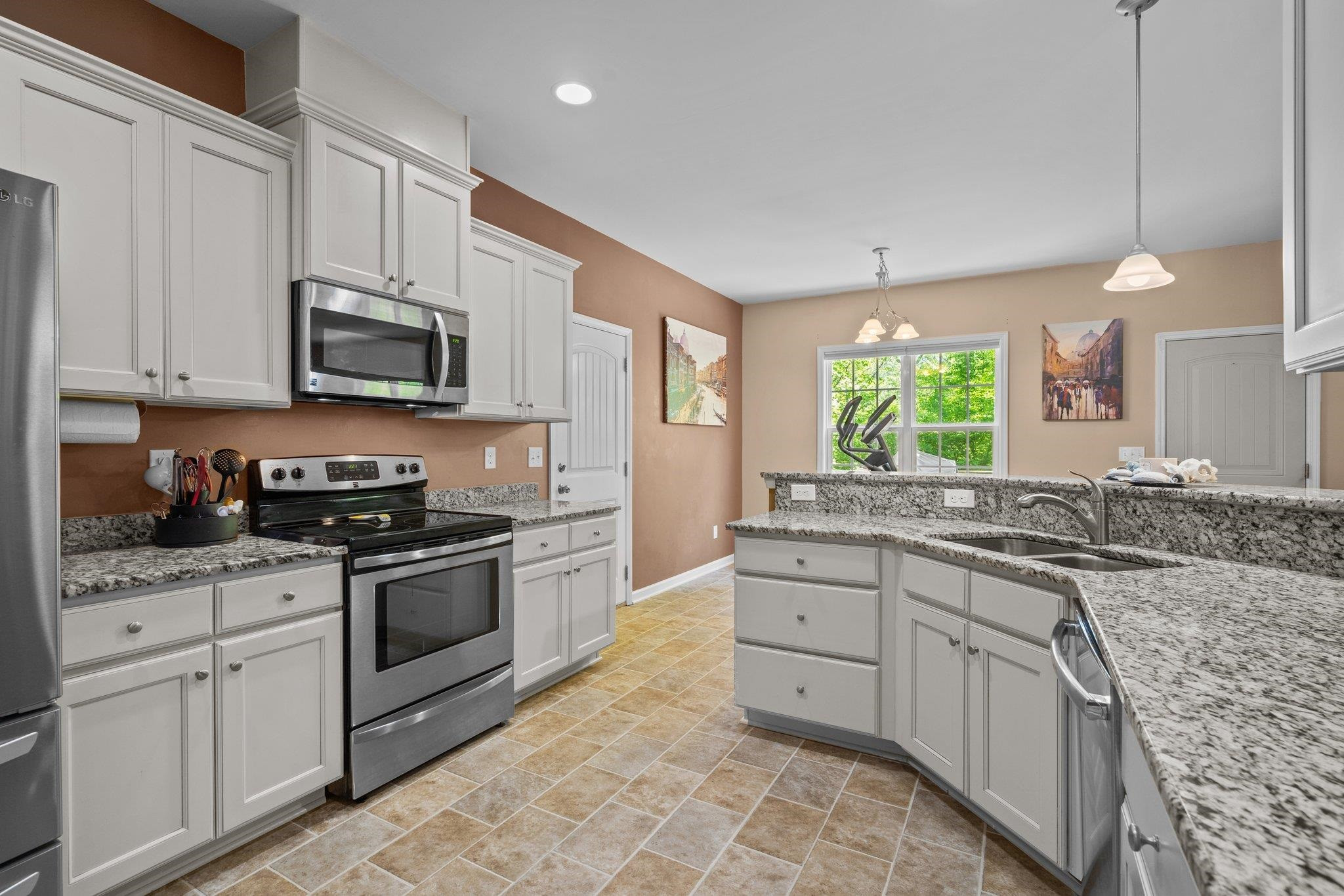 104 Griffis Drive Stem, NC 27581 - Photo 7 of 37 a kitchen with stainless steel appliances granite countertop a stove a sink and a microwave