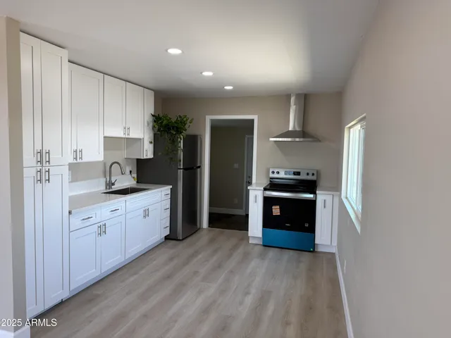 a kitchen with a refrigerator sink and cabinets