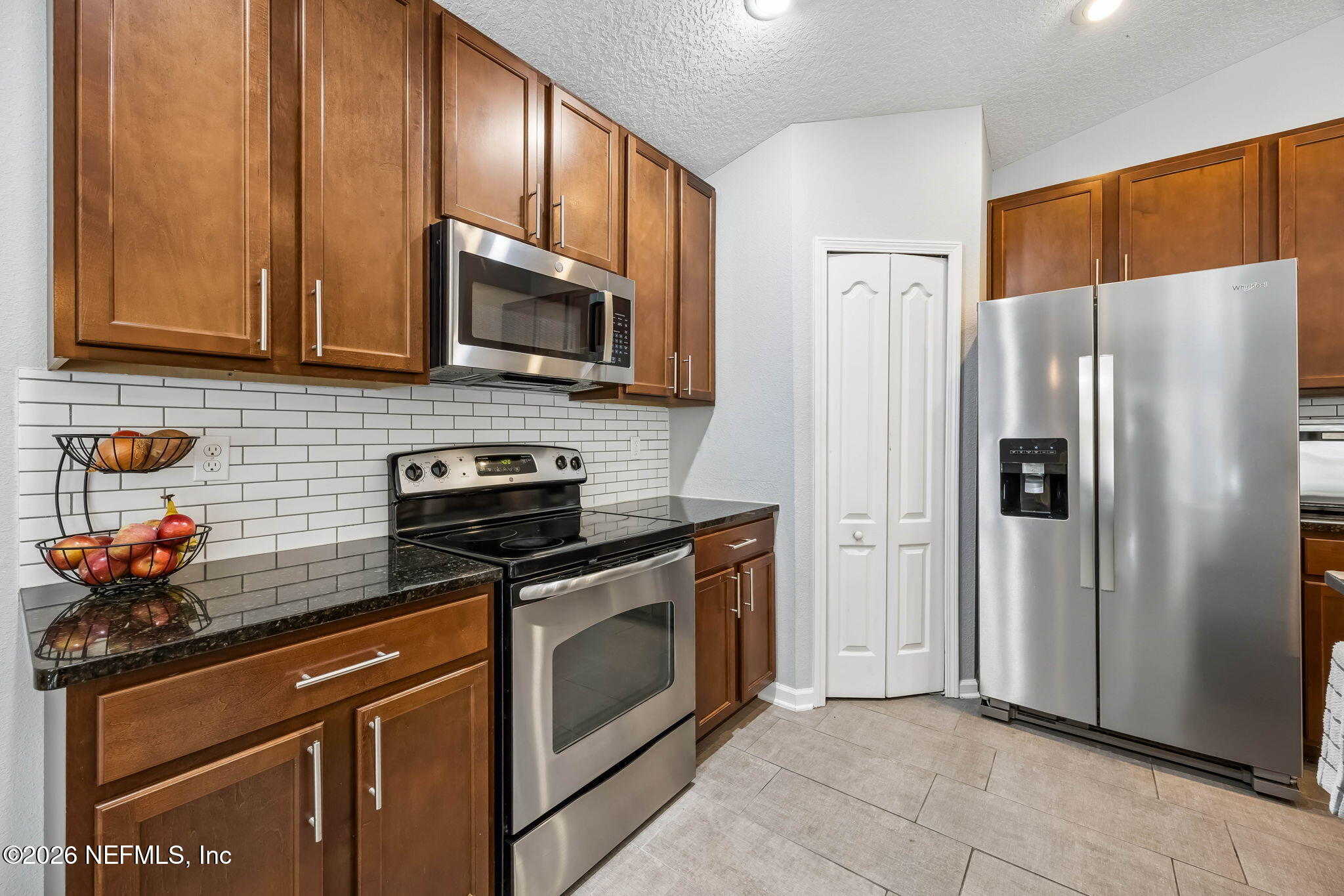 1624 Indigo Street Fernandina Beach, FL 32034 - Photo 12 of 22 a kitchen with stainless steel appliances granite countertop a refrigerator stove and microwave