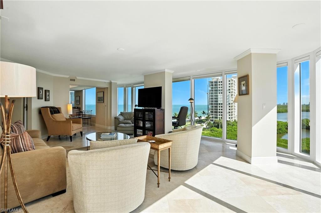 20 Seagate Drive, Unit 803 Naples, FL 34103 - Photo 21 of 40 Living area featuring ornamental molding and expansive windows