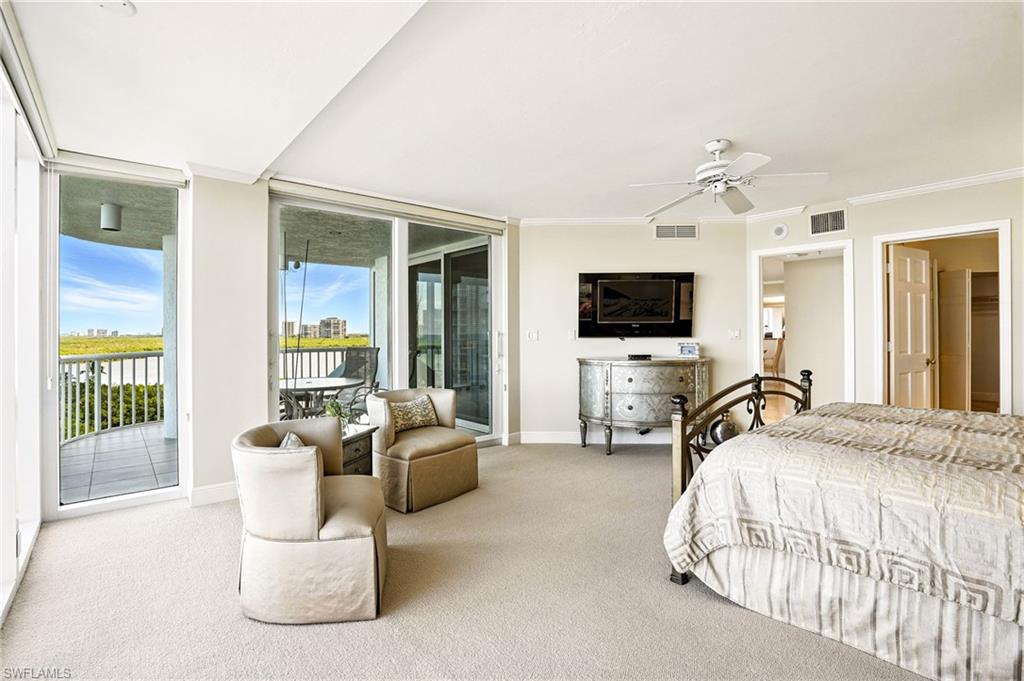 20 Seagate Drive, Unit 803 Naples, FL 34103 - Photo 25 of 40 Carpeted bedroom featuring access to outside, a ceiling fan, ornamental molding, and expansive windows