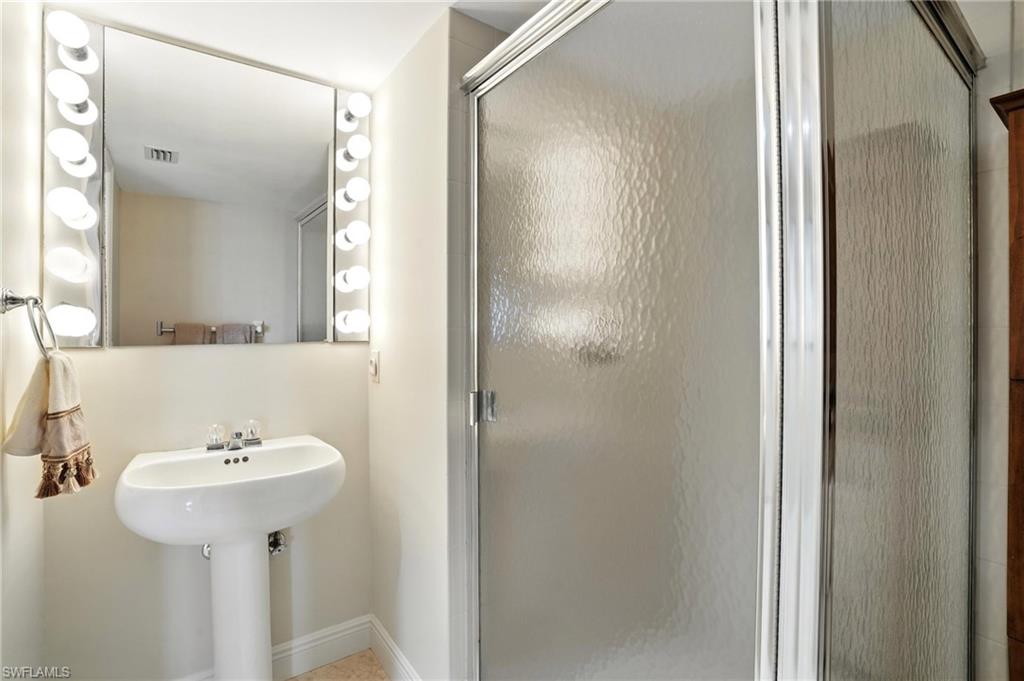 20 Seagate Drive, Unit 803 Naples, FL 34103 - Photo 36 of 40 Bathroom with a shower stall and baseboards