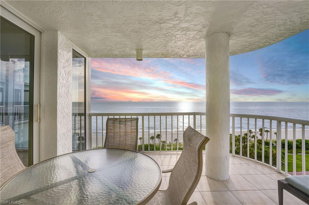 20 Seagate Drive, Unit 803 Naples, FL 34103 - Photo 38 of 40 Balcony at dusk with view of water and beach and outdoor dining space