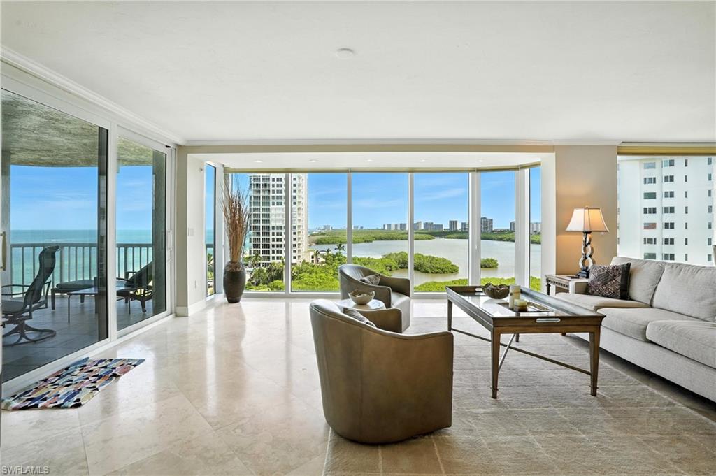 20 Seagate Drive, Unit 803 Naples, FL 34103 - Photo 6 of 40 Living room featuring floor to ceiling windows, a water view, a view of city, and crown molding