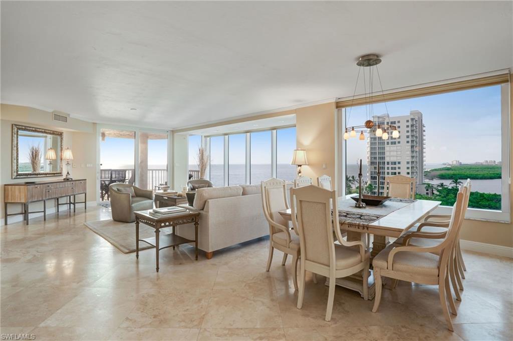 20 Seagate Drive, Unit 803 Naples, FL 34103 - Photo 8 of 40 Dining room featuring a water view and a chandelier